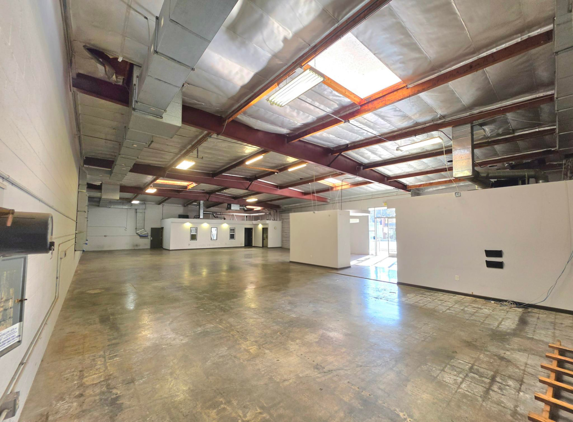 Open floor plate lit by skylights with exposed structure overhead
