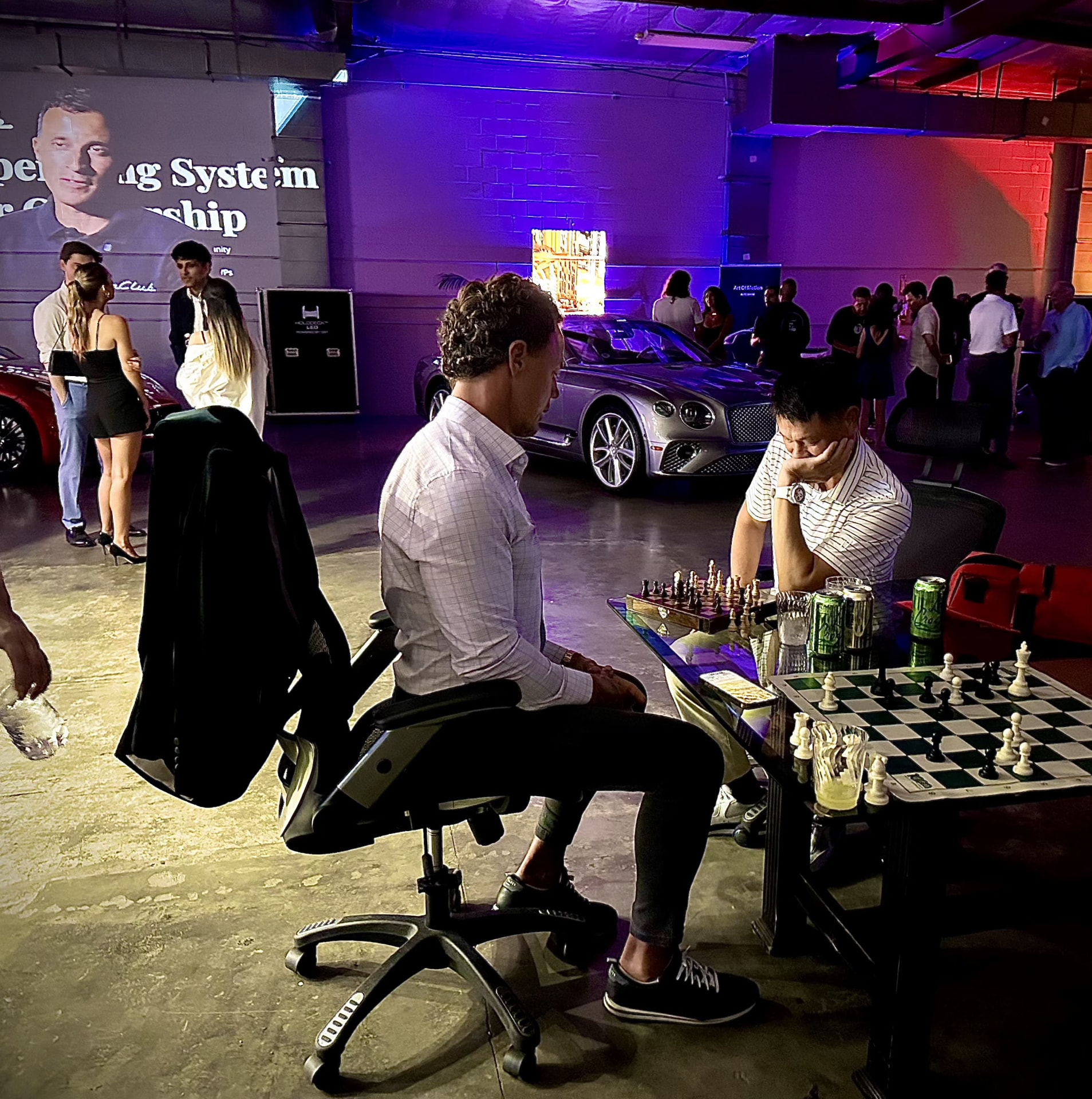 Guests playing chess beside a Bentley during the August event