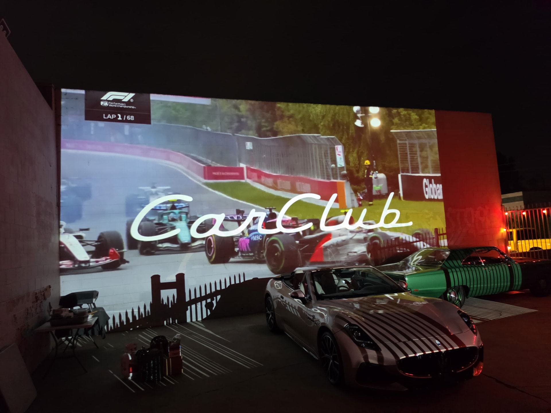 Formula 1 projection above a Maserati convertible at the August Cars & Capital gathering