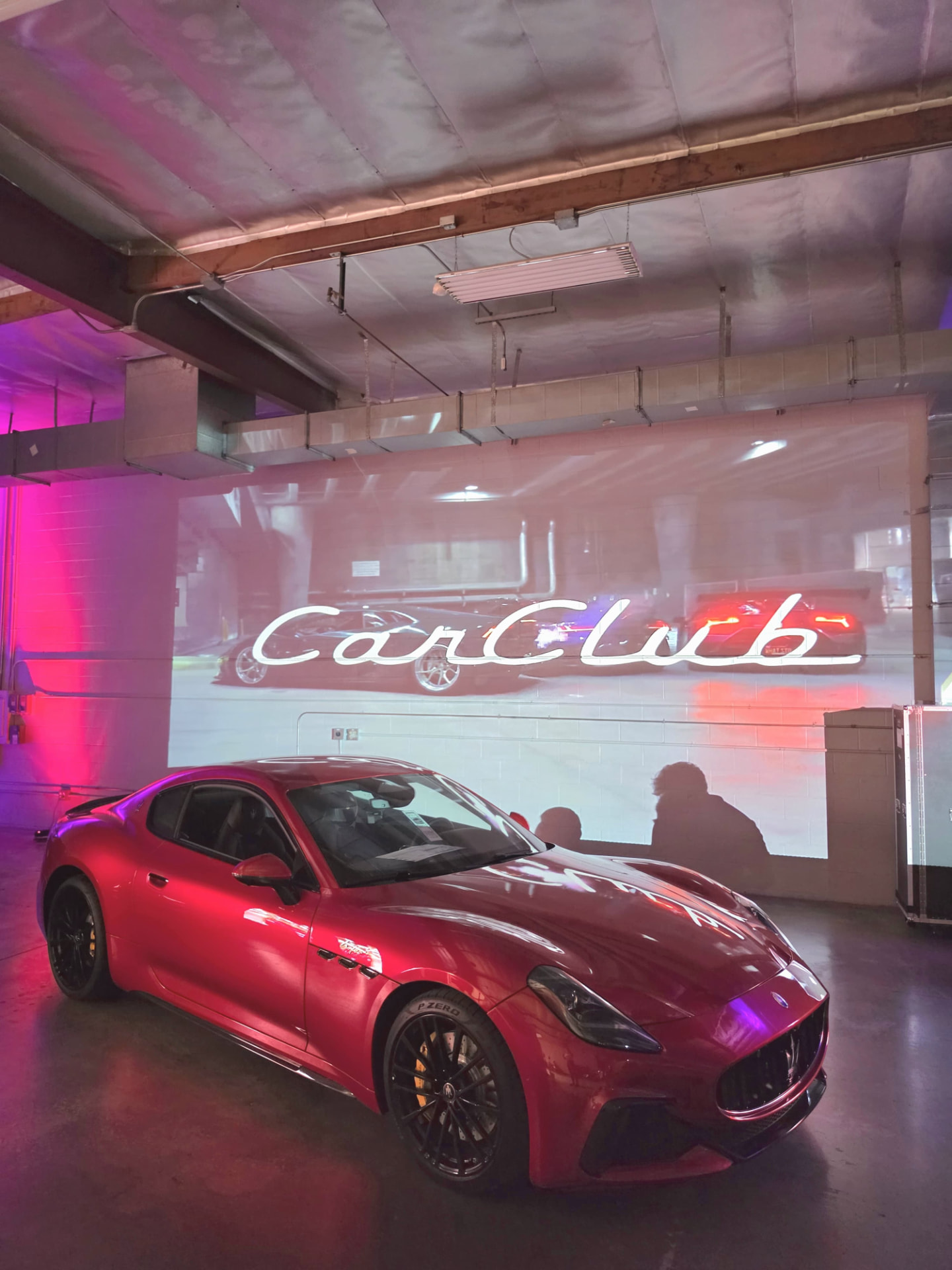 Red Maserati beneath the CarClub projection inside 3370 Livonia