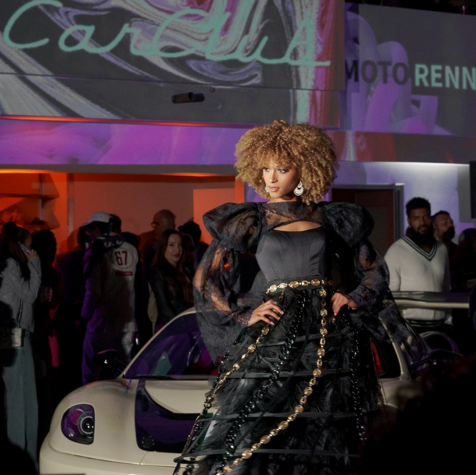 Model in black couture beneath the CarClub projection