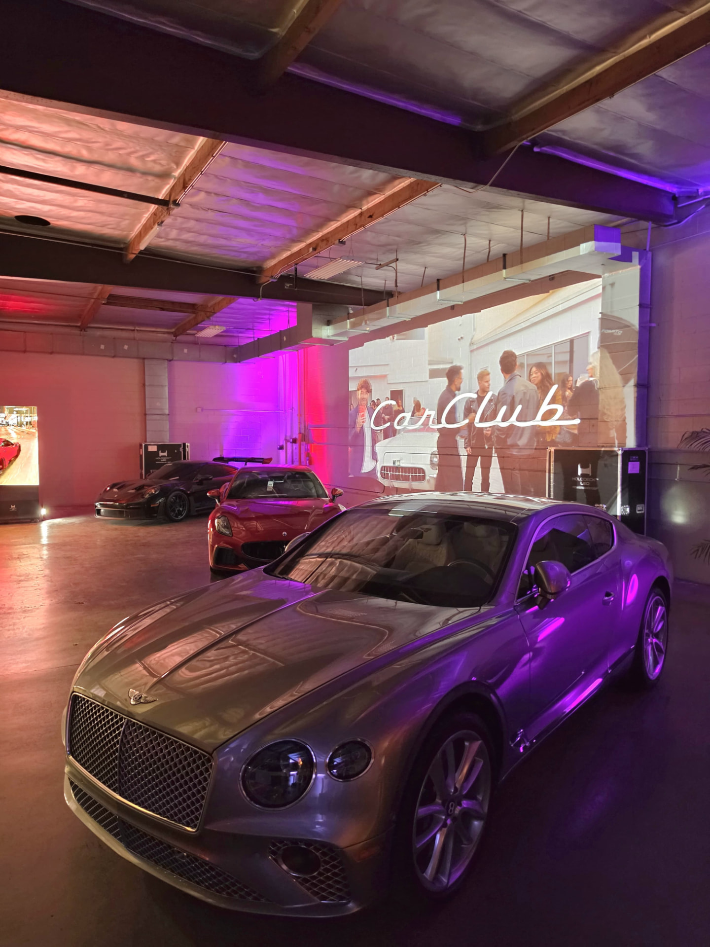 Bentley, Maserati and Porsche lined up inside the building